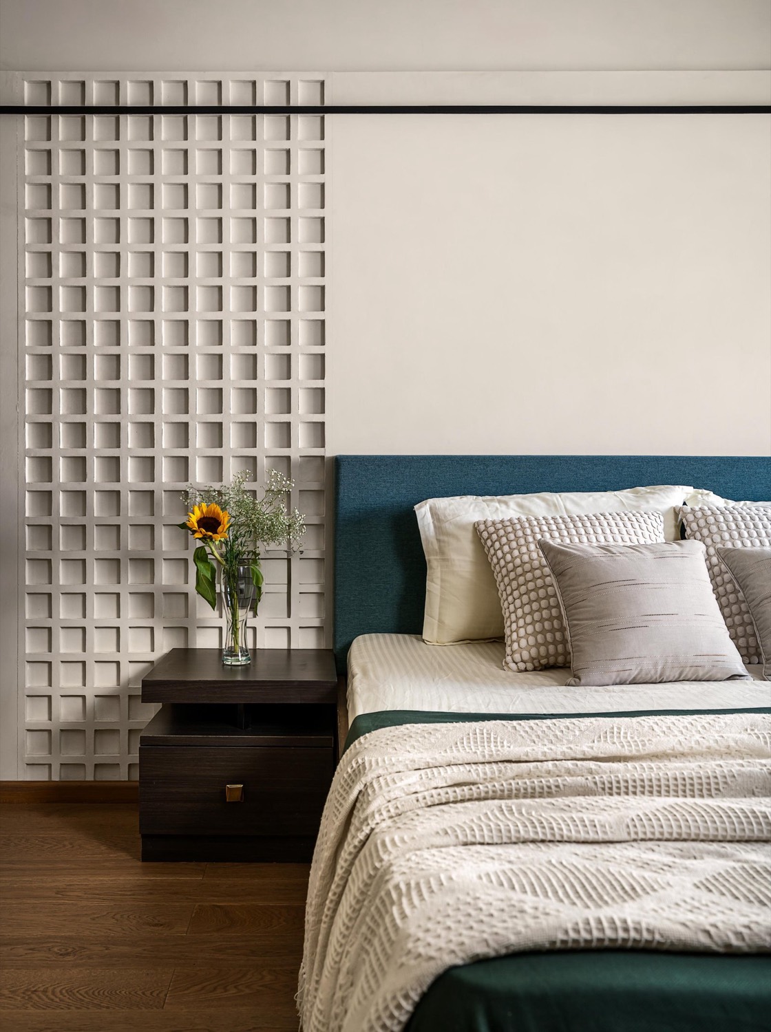 Guest bedroom with sculptural lattice screen and teal upholstered headboard